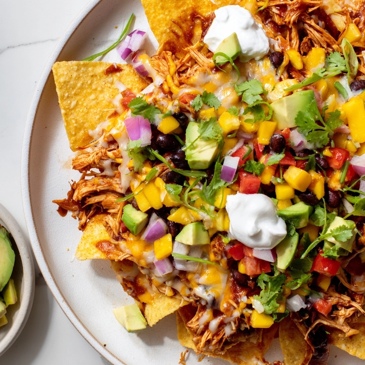 Mango Salsa BBQ Chicken Nachos: a vibrant baked platter with fresh, bright toppings.