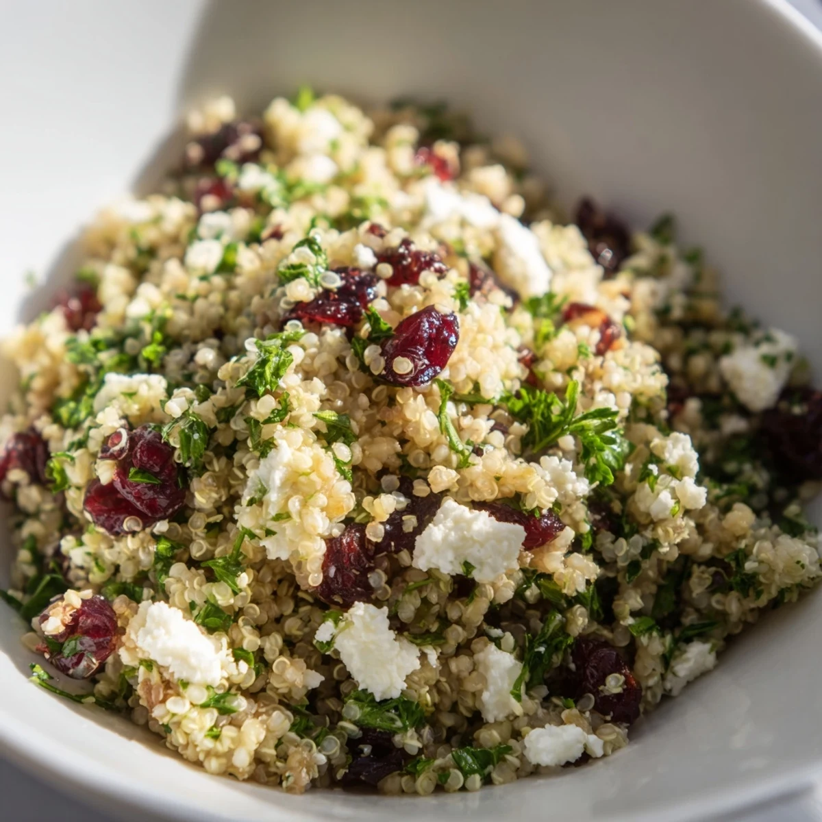 Delicious quinoa salad featuring tangy feta and sweet cranberries for a refreshing summer meal.  