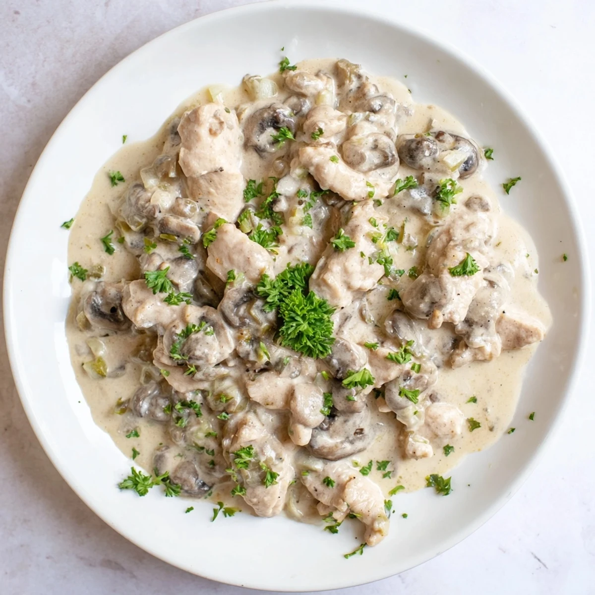 A hearty bowl of Creamy Chicken Stroganoff glistens with a velvety sauce, perfect for a cozy dinner.