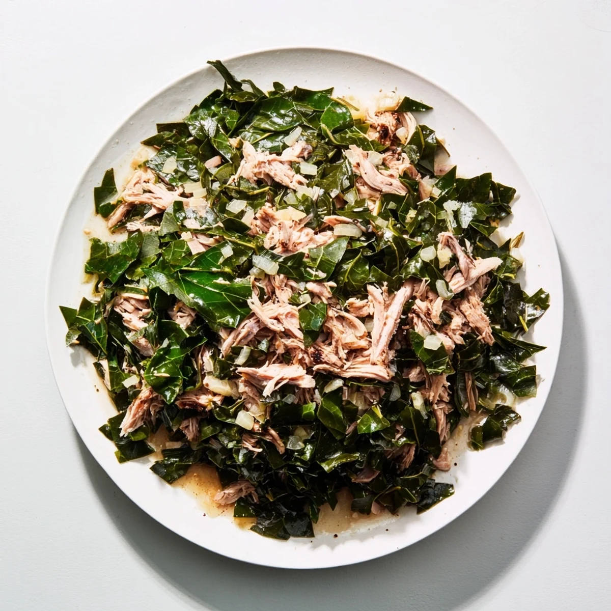 A steaming bowl of Southern style collard greens with turkey, a flavorful and hearty dish, ready to eat.