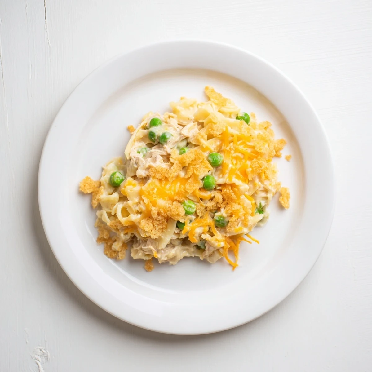 Enjoy a warm slice of homemade Creamy Tuna Noodle Casserole, topped with golden Ritz crackers.