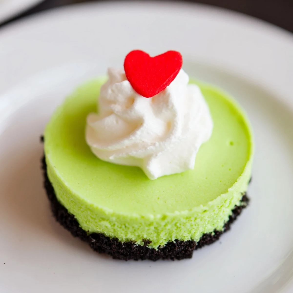 Fluffy, vibrant green Grinch Mini Cheesecakes topped with festive sprinkles for Christmas dessert.