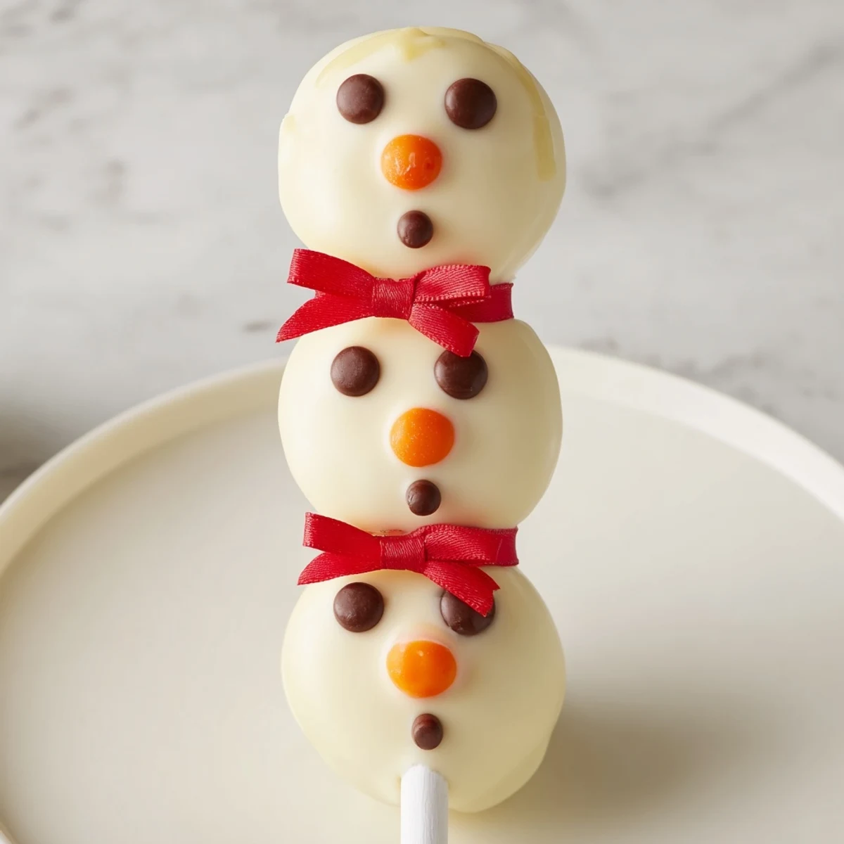 Express Snowman Marshmallow Pops, a delicious winter dessert with melted chocolate and festive faces.