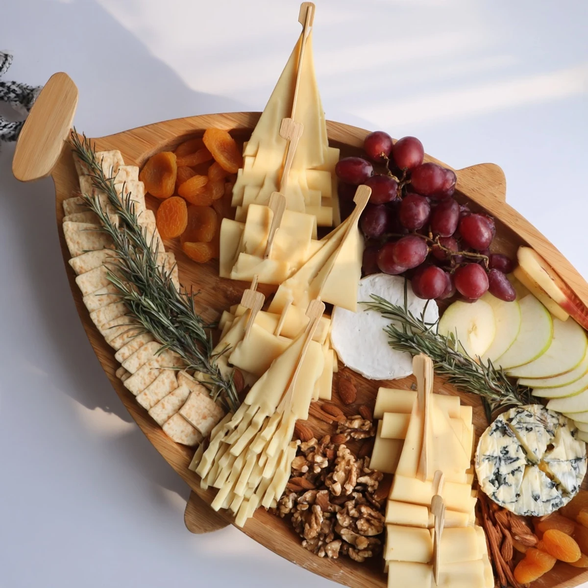 Elegant Boat-Shaped Cheese Platter offering a stunning display of brie, manchego, and cheddar.