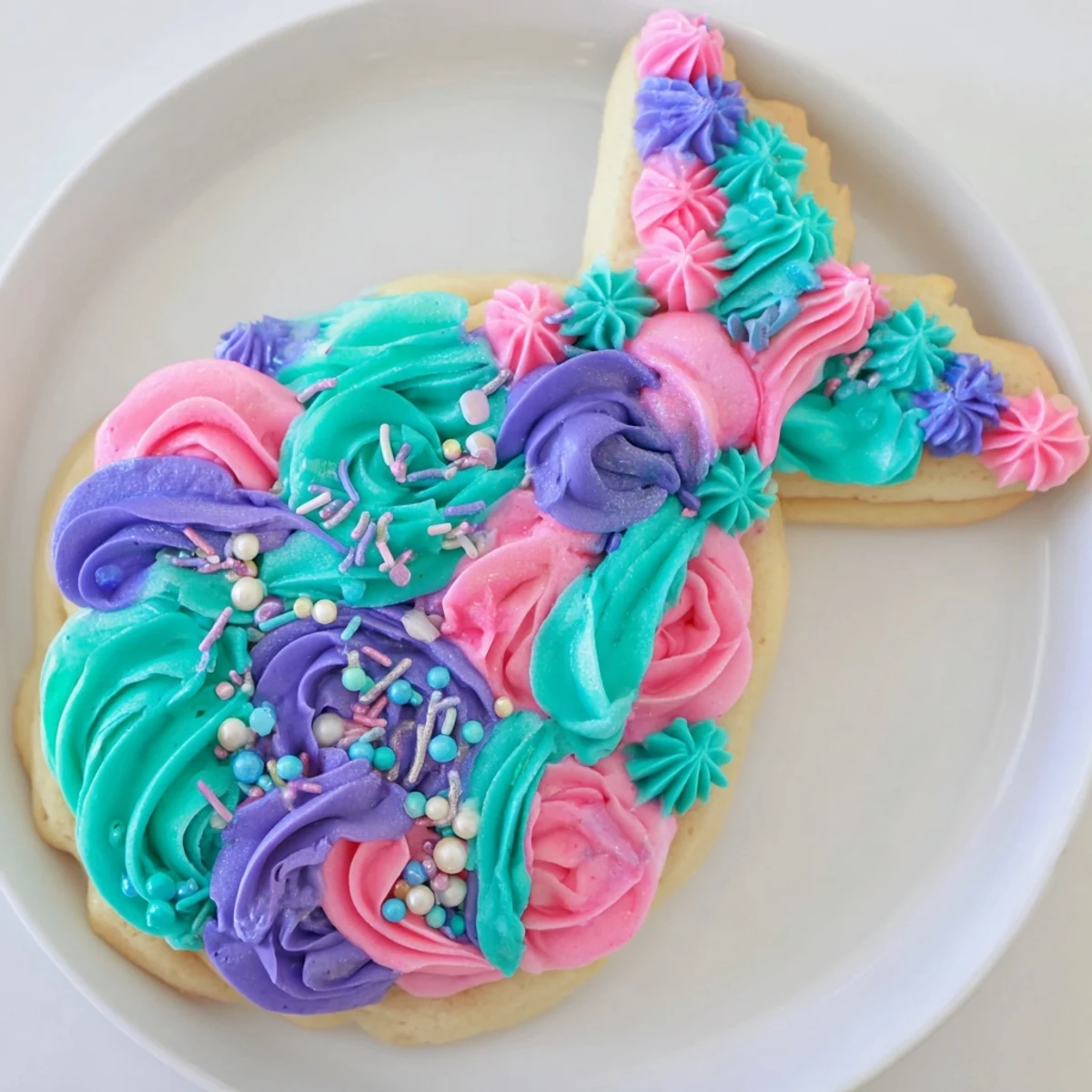 Vibrant mermaid tail sweets, frosted with shimmering blue buttercream and sparkling candy pearls.