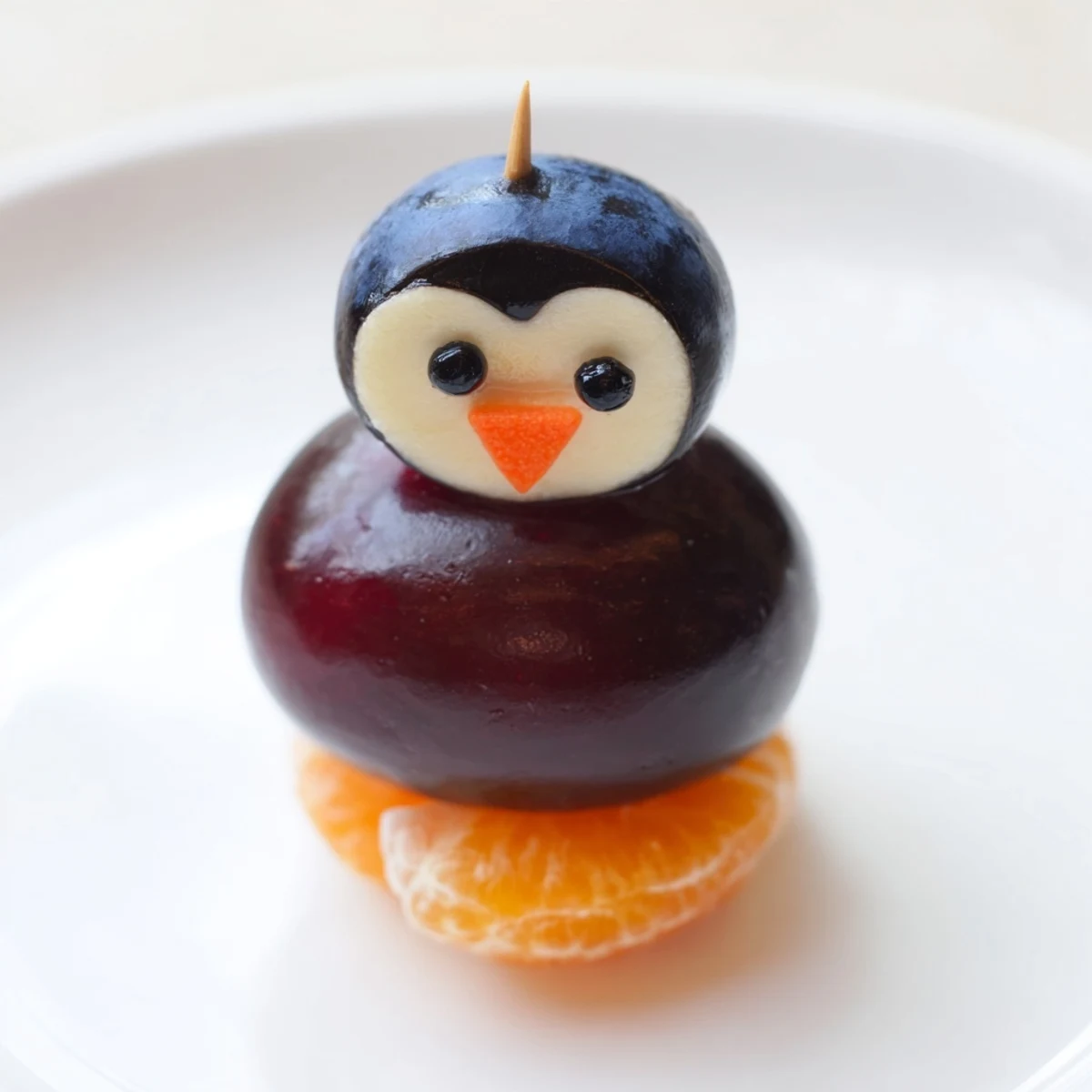 Colorful Penguin Fruit Skewer Army featuring strawberry bellies, grape bodies, and happy blueberry heads.
