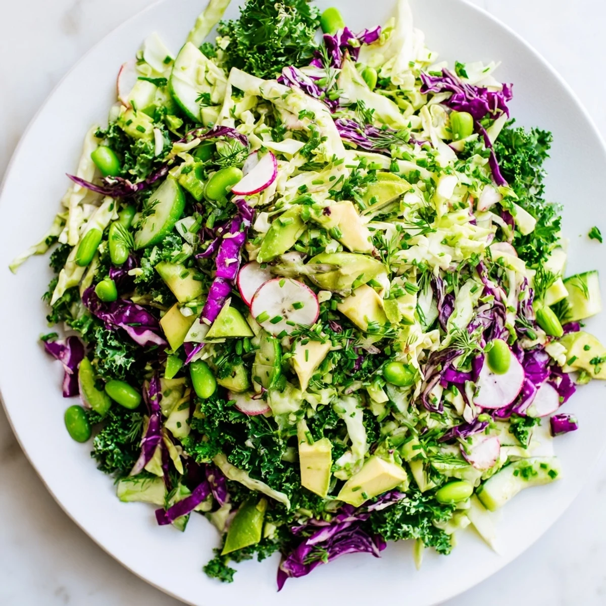 A refreshing bowl of Green Goddess Detox Cabbage Salad with crunchy cabbage and sliced cucumbers ready to eat.