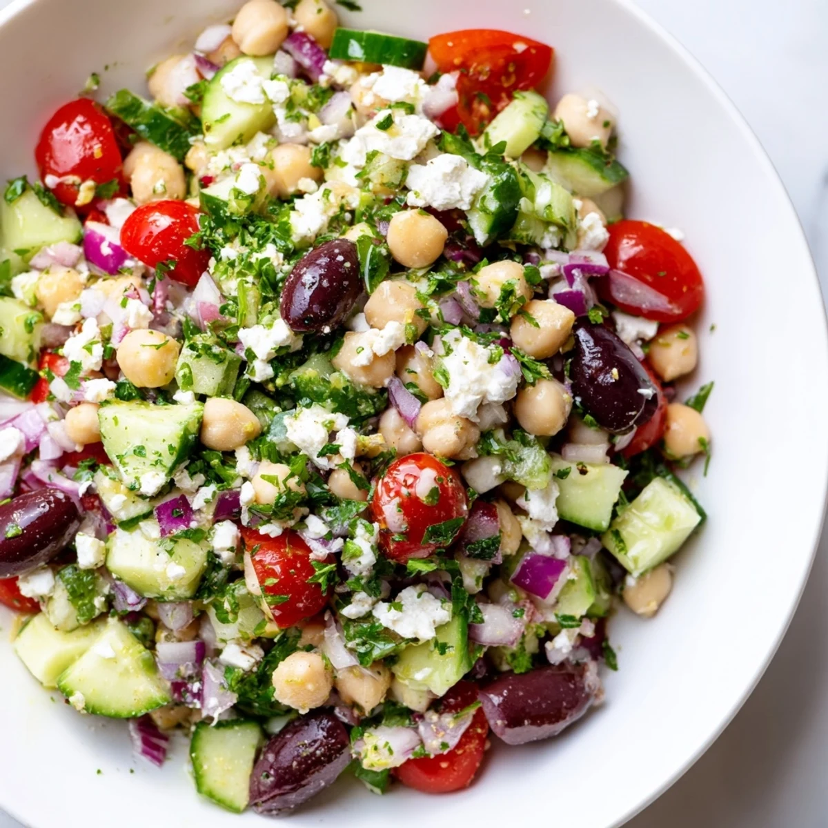 A bright and colorful Mediterranean Chickpea Salad, drizzled with zesty lemon dressing, perfect for sharing.