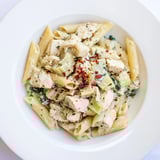 A close-up of Creamy Spinach Artichoke Protein Pasta Skillet: pasta twirled with spinach and artichokes.