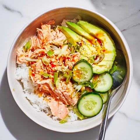 Leftover salmon and rice bowl garnished with avocado, cucumber, and pickled ginger.  