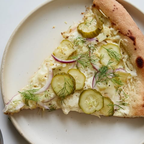 Tangy pickle pizza topped with creamy sauce, mozzarella, and crunchy dill pickles.  
