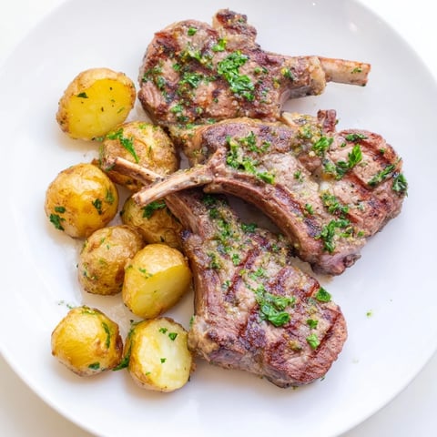 Juicy herbed lamb chops alongside golden, crispy roasted potatoes make a flavorful dinner.