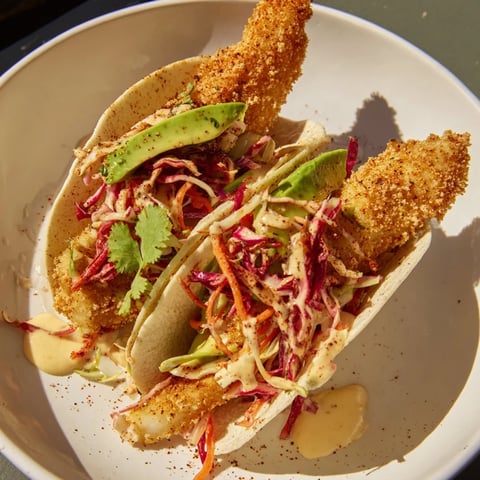 Golden, crispy fish tacos with vibrant slaw offer a delicious, flavorful Mexican-American cuisine experience.