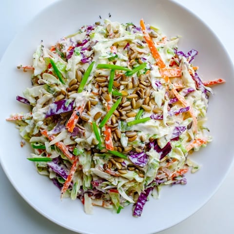 Freshly made crunchy coleslaw salad with vibrant shredded vegetables and creamy dressing.