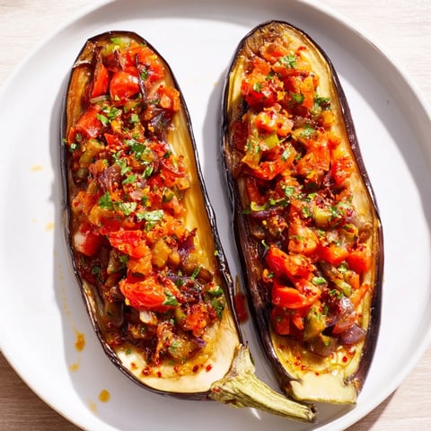 Golden-brown Imam Bayildi, a Turkish eggplant dish, filled with a vibrant tomato and onion medley.