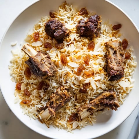 Golden raisins and almonds garnish a steaming platter of Kabsa rice, a Saudi Arabian specialty.