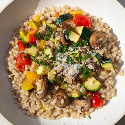 A warm bowl of Pearled Barley Creamy Bowl, featuring roasted vegetables and fresh parsley.