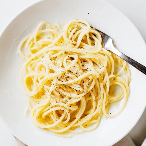 Freshly grated Pecorino Romano coats al dente spaghetti in this classic Spaghetti Cacio e Pepe, served with extra black pepper.  