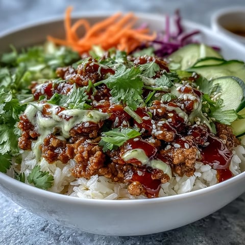 Spicy Bang Bang Turkey Rice Bowls garnished with sesame seeds and cilantro in a white bowl.