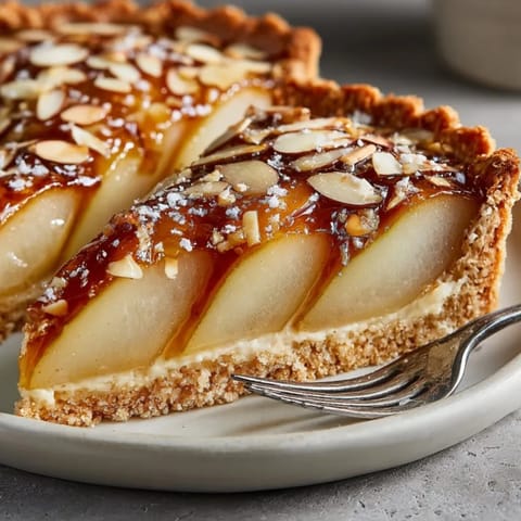 Rich, dark amber hot spiked mulled cider in a glass, garnished with orange slices and star anise.