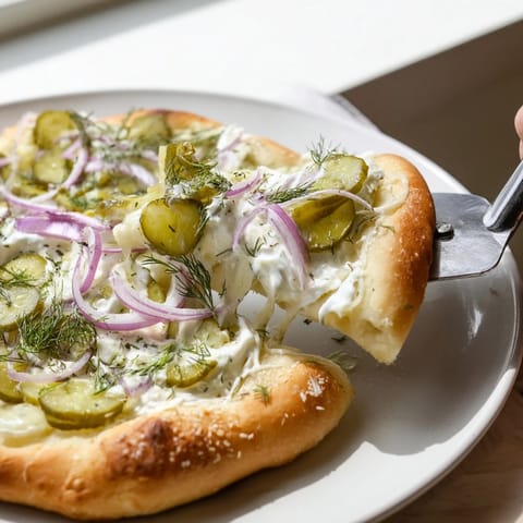 Savory Pickle Pizza featuring tangy crème fraîche and crunchy dill pickle slices.  