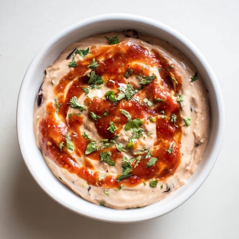 Creamy, smooth Spicy Black Bean Dip ready to serve with crispy tortilla chips for a snack.