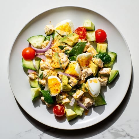 This High-Protein Chicken and Egg Salad features tender chicken and vibrant, chopped vegetables.