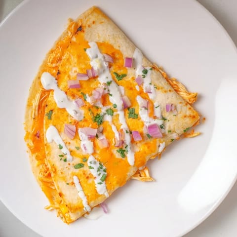 Golden-brown Buffalo Chicken Quesadilla, oozing melted cheese and spicy chicken filling, ready to serve.