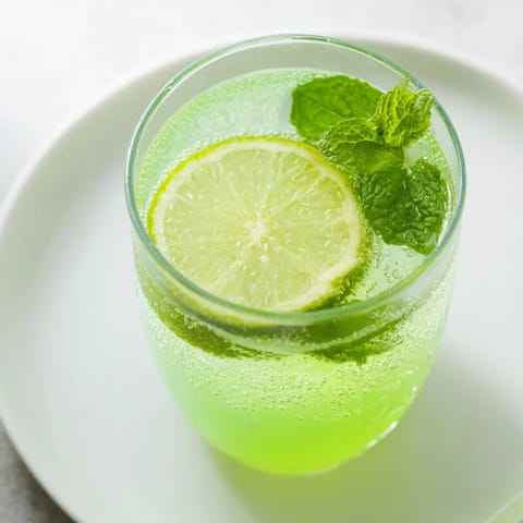 Chilled Mint Lime Agua Fresca sparkles invitingly in a tall glass, perfect for a sunny afternoon.
