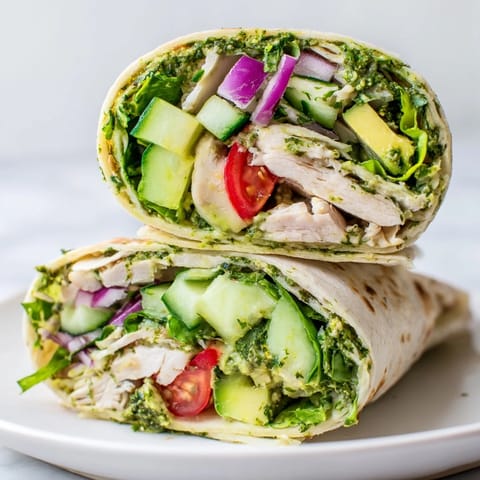 Fresh herbs, tender grilled chicken, and crisp vegetables rolled tightly in a warm flour tortilla ready to be sliced and served.