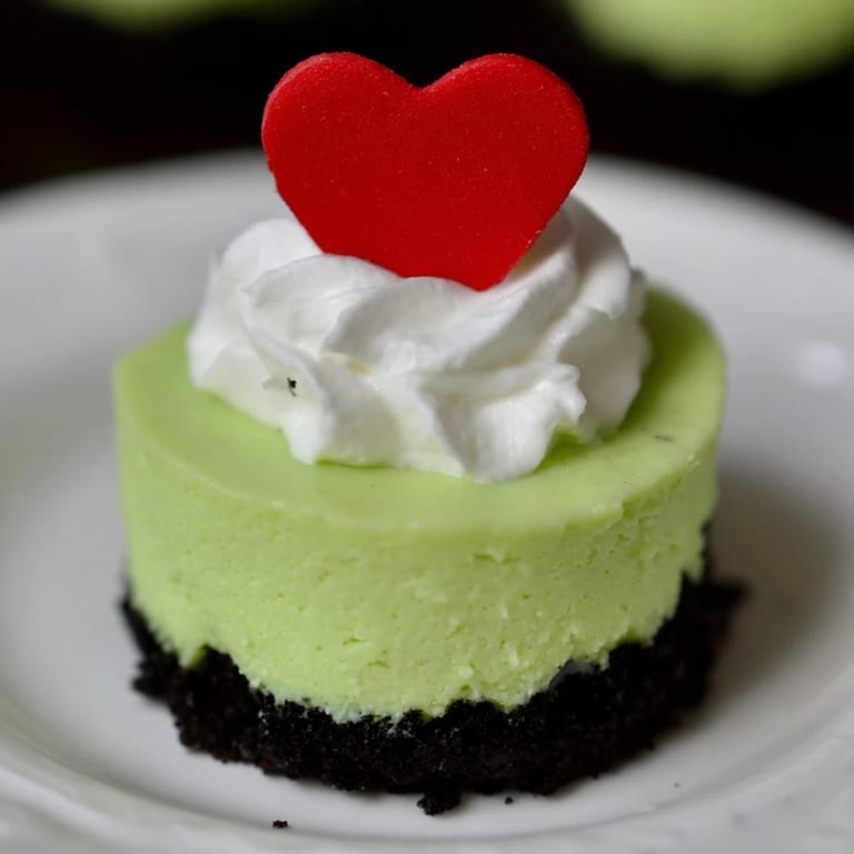 Bright green Grinch Mini Cheesecakes, served cold, offering a sweet and festive bite.