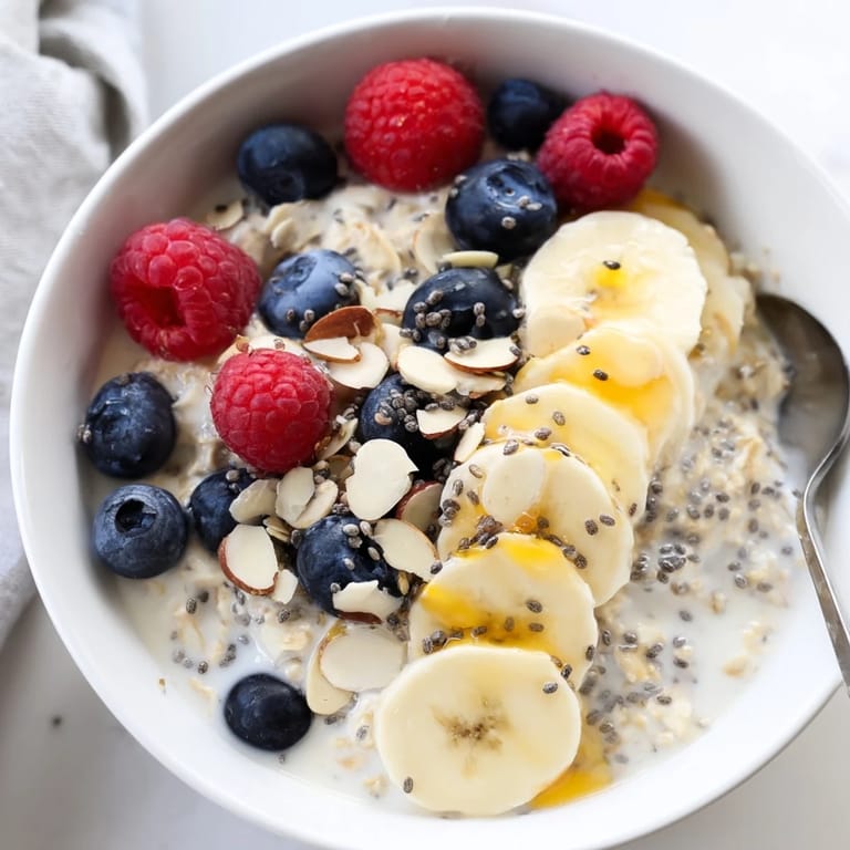 A close-up of overnight oats with chia seeds layered with berries and nut butter, offering a wholesome, protein-rich start to the day.
